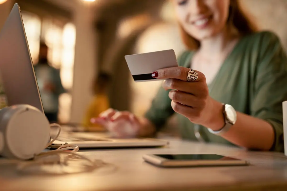 closeup-female-entrepreneur-using-laptop-credit-card-online-shopping-while-working-late-office-1788204206