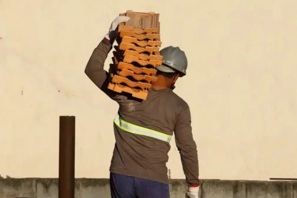 Homem carregando tijolos