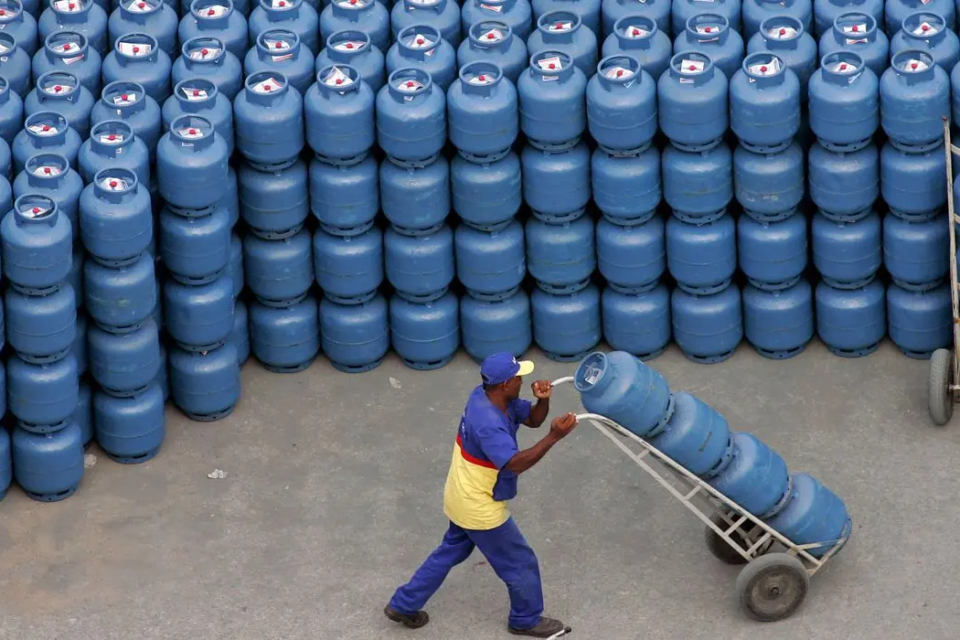 Homem transporta botijões de gás de cozinha em distribuidora (Foto: Agência BrasiL)