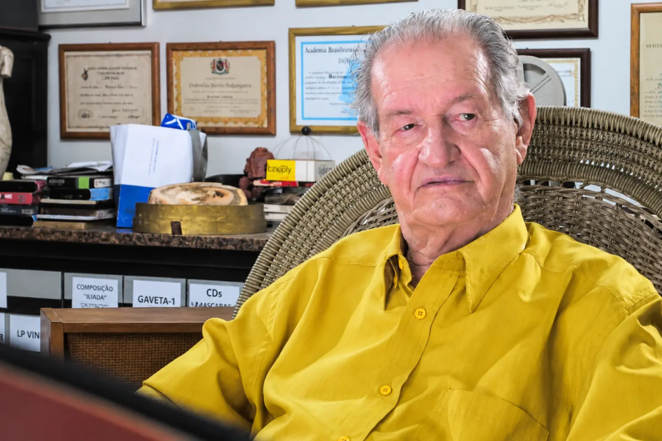 Bariani Ortêncio em seu escritório, cercado por livros, documentos e homenagens acumuladas ao longo da trajetória dedicada à cultura e à memória de Goiás (Foto: Reprodução/Facebook)