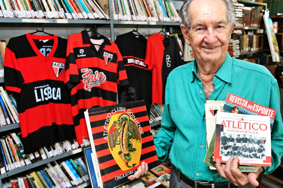 Bariani Ortêncio posa com camisas e publicações históricas do Atlético Goianiense, clube pelo qual atuou como goleiro nos primeiros anos em Goiânia (Foto: Atlético Goianiense)