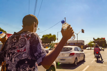 Homem segura garrafa d´água em dia ensolarado