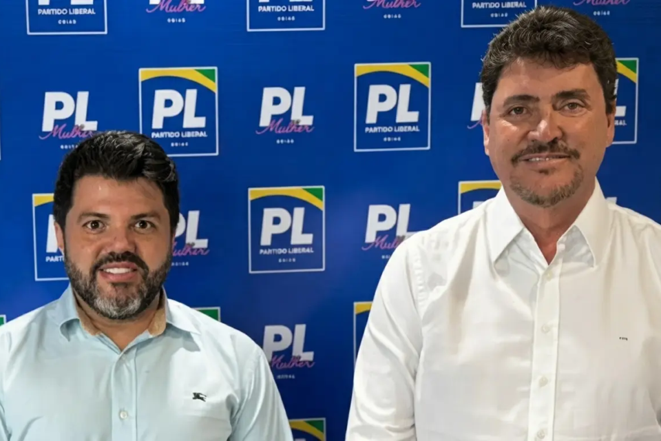 Márcio Corrêa ao lado de Wilder Morais diante de backdrop do PL